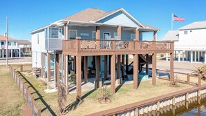 A two-story house with a balcony, a flag, and a small pool.
