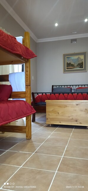 A room with bunk beds, a wooden bench, and a framed picture on the wall. - Immaculate 2-bed Garden Cottage in Beaufort West (Beaufort West)
