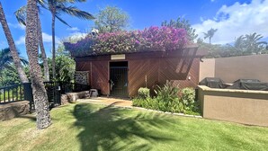 A residential property with a wooden storage shed, a well-maintained lawn, and a variety of plants and trees. - Wailea Elua, #0801 2 Bedroom Condo by RedAwning (Kihei)