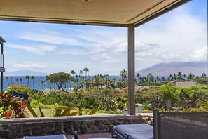 A covered outdoor seating area with a view of the ocean and mountains. - Wailea Elua, #2003 1 Bedroom Condo by RedAwning (Kihei)