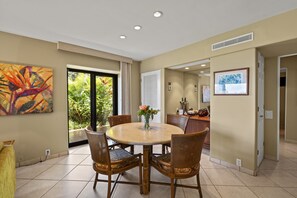 A dining area with a round table, four chairs, and a vase with flowers. - Wailea Elua, #2003 1 Bedroom Condo by RedAwning (Kihei)