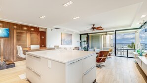 Una cocina moderna con una isla central, armarios de madera y vistas al exterior.