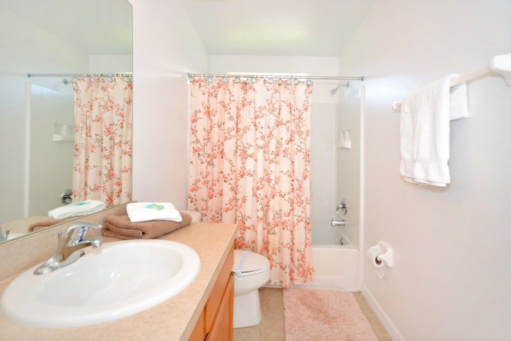 A bathroom with a sink, toilet, and shower.