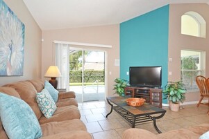 Una sala de estar con un sofá, un televisor y una mesa de centro.