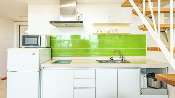 Una cocina compacta con microondas, un lavaplatos y estufa.