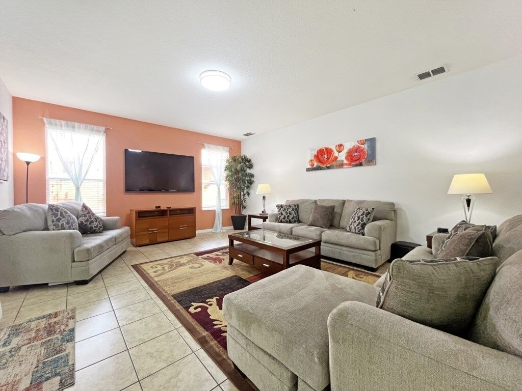 A living room with two sofas, a coffee table, a TV, and a painting on the wall.