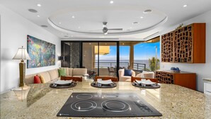 A modern kitchen with a central island, a dining area with a view, and a traditional wooden cabinet. - Polo Beach Club Two Bedrooms - Ground Floor by Coldwell Banker Island Vacations (Kihei)