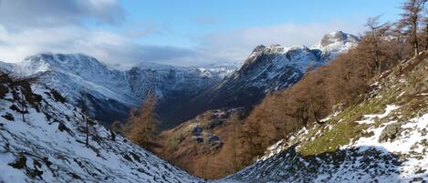 A mountainous landscape with snow-covered slopes and a valley.