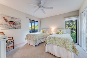 A bedroom with two beds, a ceiling fan, a painting, and a view of greenery outside. - Wailea Elua, #0105 2 Bedroom Condo by RedAwning (Kihei)