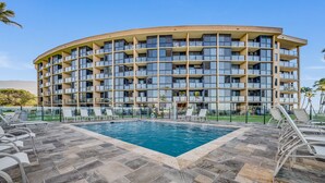 A multi-story hotel with a swimming pool and outdoor seating. - Kihei Surfside, #113 1 Bedroom Condo by RedAwning (Kihei)
