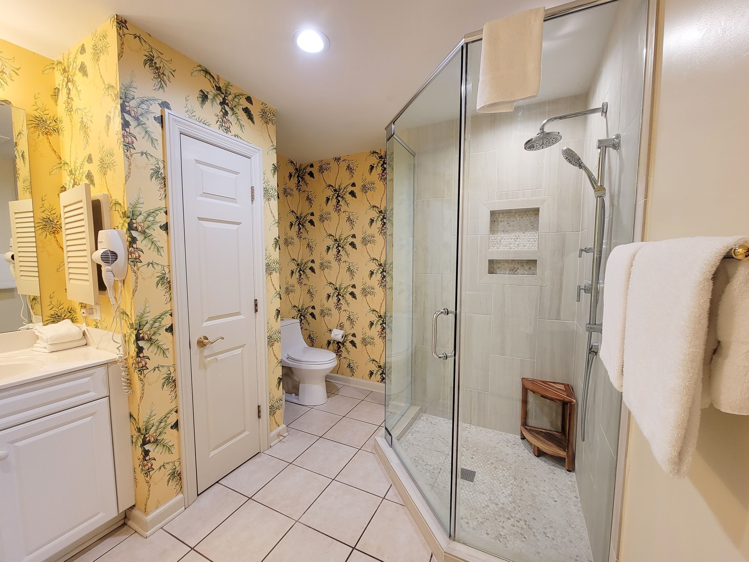 A bathroom with a shower, toilet, and vanity.