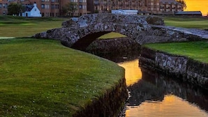 A stone bridge over a water channel with a large building in the background. - Standrews- Sleeps4- Familyfriendly- Newlyrenovated (St. Andrews)