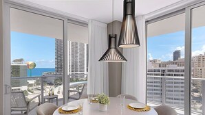 A modern dining area with a large table, chairs, and pendant lights. - Wrap Around Balcony|Insane Amenities|Amazing Pools (Hollywood)