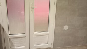 Une porte dotée de panneaux en verre dépoli et d’une poignée blanche.