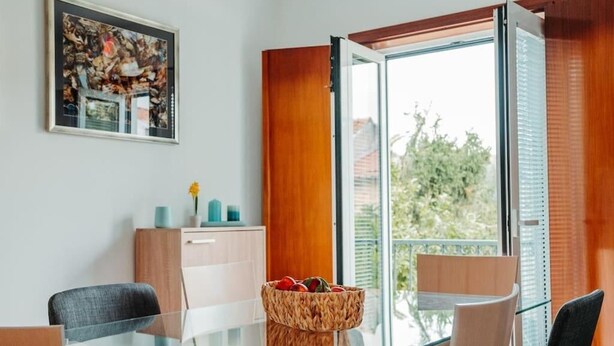 Un espace repas moderne avec une table en verre, des chaises et un meuble en bois.