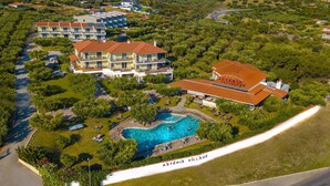 Ett stort hotellkomplex med flera byggnader, en swimmingpool och ett område med strand.