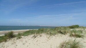 A beach with sand dunes and wind turbines in the distance. - Chalet for 4 persons in Kamperland, close to beach and sea (kamperland)