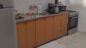 A kitchen with a refrigerator, stove, sink, and countertop appliances. - Olive Palace Restaurant and Lounge  (al-Khader)