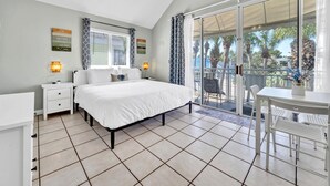 A bedroom with a bed, a nightstand, a desk, and a chair. There is a ceiling fan and a window with curtains. - Destin Entire Crystal Beach Cottage~Steps to Beach & Pool~Prime Location (Destin)
