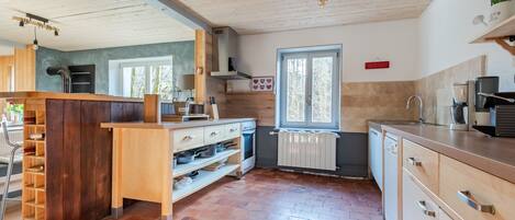 Une cuisine moderne avec des meubles en bois, un îlot central intégré et une fenêtre qui laisse entrer la lumière naturelle.
