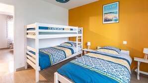 A room with bunk beds, a bed, a desk, and a lamp. - La Janne - Maison avec jardin (Saujon)