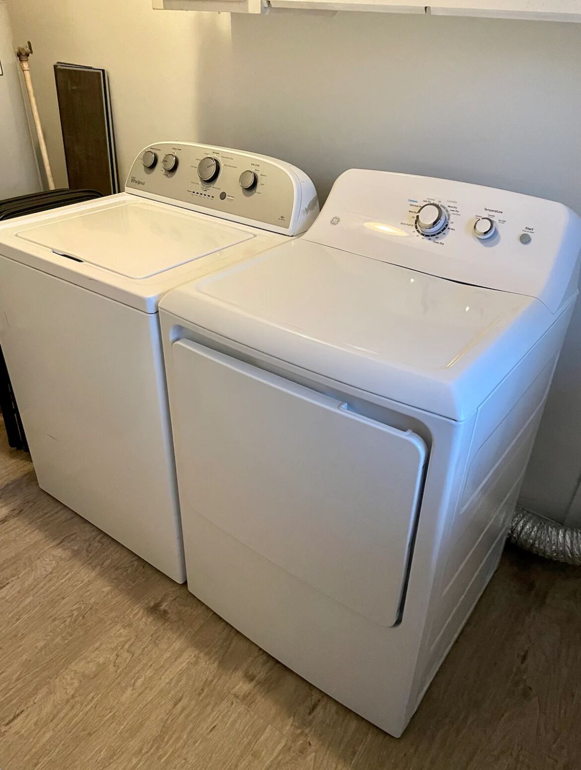 A front view of a compact, white, front-loading washer and dryer unit with a control panel on top.