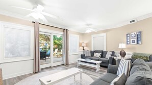 A living room with a grey sofa, a white coffee table, and a ceiling fan.