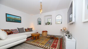 A modern living room with a white sofa, patterned rug, and a framed picture on the wall. - Casa Ambi (Trogir)