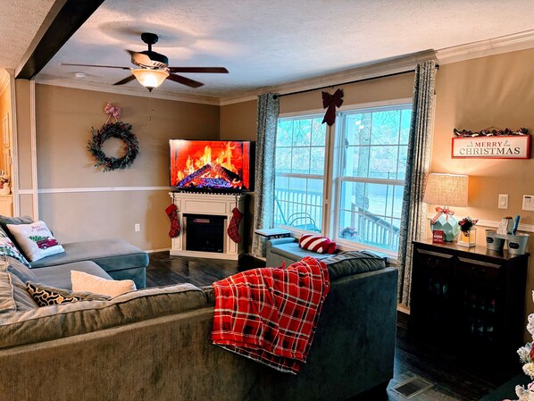 A cozy living room with a fireplace, a television, and a comfortable sofa.