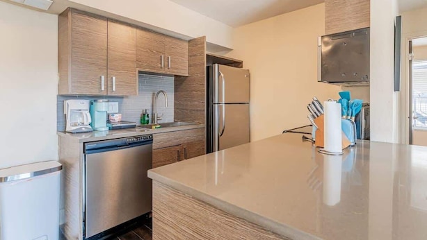 Een moderne keuken met houten kasten, roestvrijstalen apparatuur en een centraal eiland.
