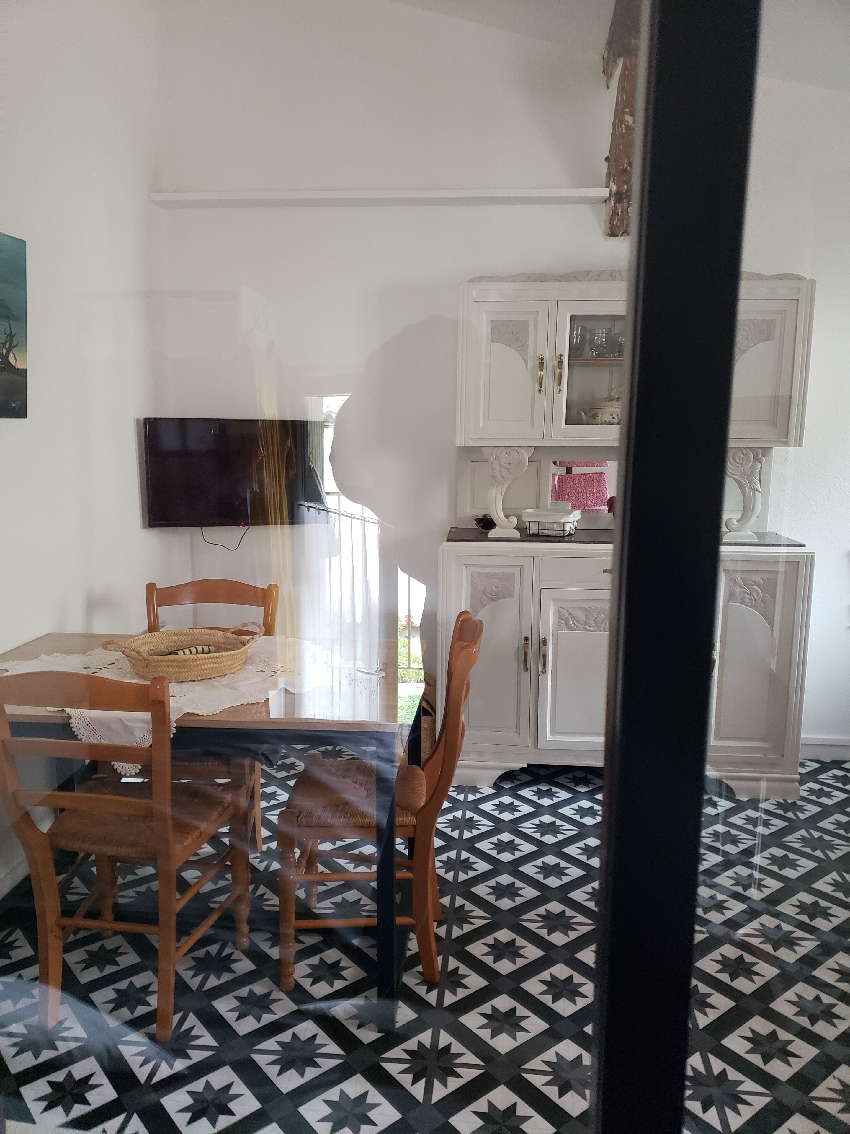 A dining area with a table, chairs, and a television.