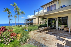 A modern house with a patio, outdoor furniture, and a view of the ocean. - Wailea Elua, #1403 2 Bedroom Condo by RedAwning (Kihei)