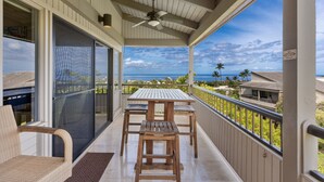 A balcony with a table and chairs, a ceiling fan, and a view of the ocean. - Wailea Ekolu, #914 2 Bedroom Condo by RedAwning (Kihei)