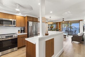 A modern kitchen with stainless steel appliances, wooden cabinets, and a large island.