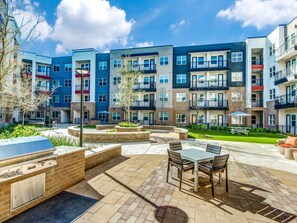 Un complesso residenziale moderno con diversi piani, aree relax all'aperto e un cortile curato.