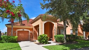 A residential house with a red-tiled roof, a driveway, and a well-maintained lawn. - Villa Marcello 4 Bedroom Home by RedAwning (Kissimmee)