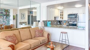 Uma sala de estar moderna com um sofá, uma mesa de centro de madeira e um ventilador de teto.