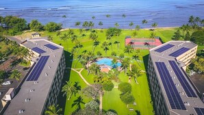 Un hotel con piscina en la azotea, paneles solares y un jardín exuberante.