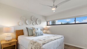 A bedroom with a bed, nightstands, wall decor, and a window with a view. - Sugar Beach Resort, #535^ 2 Bedroom Condo by RedAwning (Kihei)
