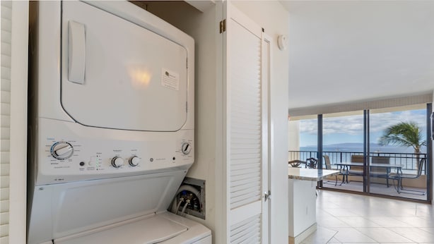 A modern laundry room with a front-loading washing machine, a dryer, and a control panel. - Sugar Beach Resort, #535^ 2 Bedroom Condo by RedAwning (Kihei)