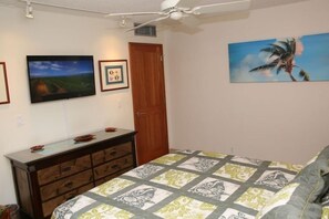 A bedroom with a bed, a dresser, a ceiling fan, and wall art. - Kihei Beach, #303 1 Bedroom Condo by RedAwning (Kihei)