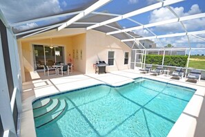 Una piscina con una estructura de sombrilla, asientos exteriores y vistas del paisaje circundante.
