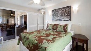 A bedroom with a bed, a ceiling fan, a painting, and a sliding door leading to a balcony. - Royal Mauian, #518^ 3 Bedroom Condo by RedAwning (Kihei)