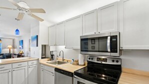 A modern kitchen with white cabinets, a microwave, an oven, and a dishwasher. - Royal Mauian, #518^ 3 Bedroom Condo by RedAwning (Kihei)