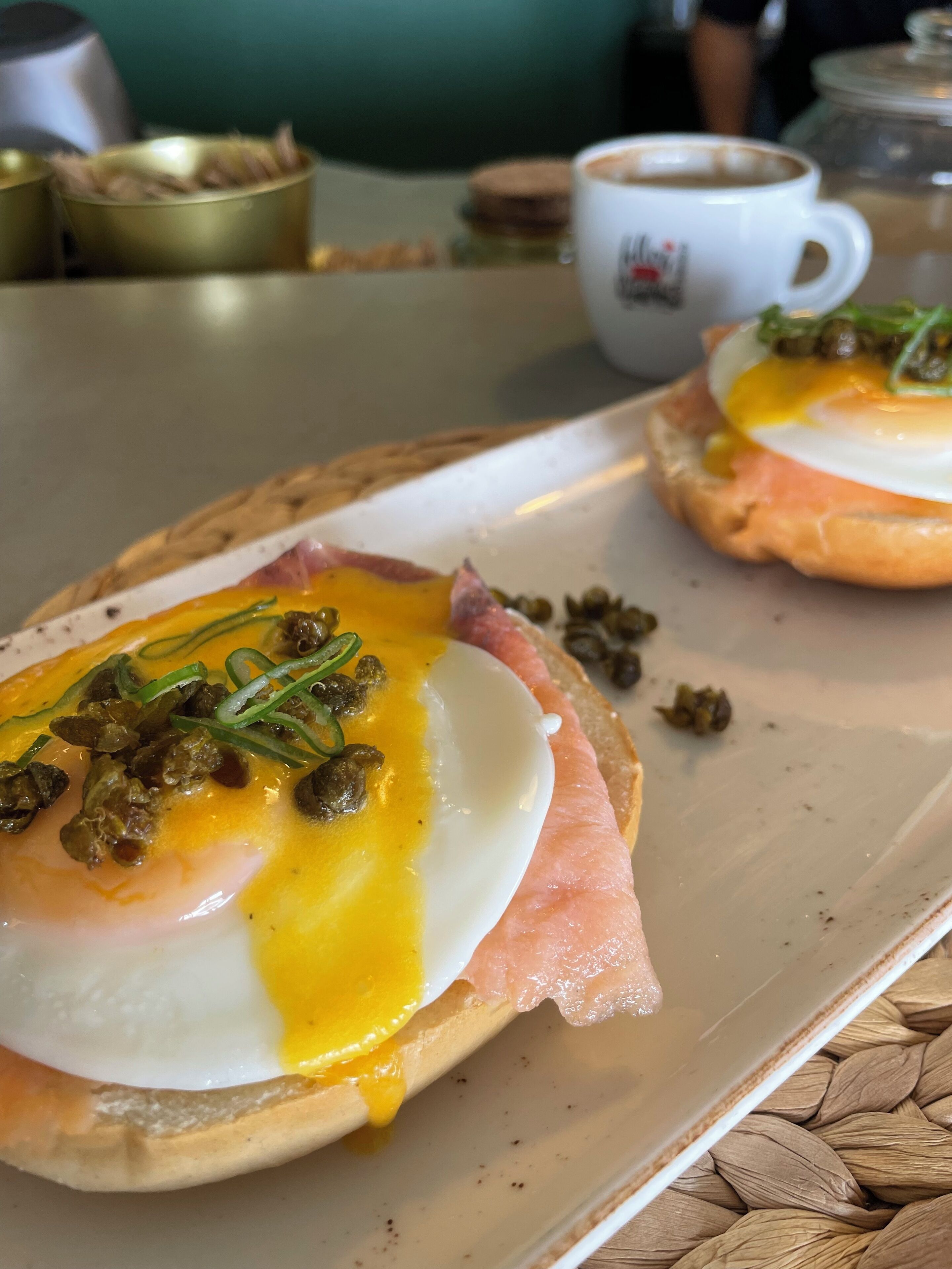 Un plato con huevos pochados, jamón y alcaparras.