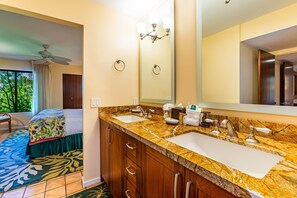 Une salle de bain d’hôtel avec deux lavabos, un grand miroir et un ventilateur de plafond.