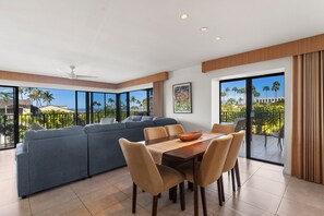 A modern living room with a dining area, large windows, and a view of palm trees. - Wailea Elua, #1503 2 Bedroom Condo by RedAwning (Kihei)