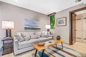 A modern living room with a sofa, two side tables, a coffee table, and artwork on the walls. - Wailea Elua, #1305^ 3 Bedroom Condo by RedAwning (Kihei)