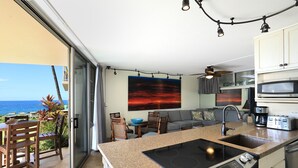 Una cucina moderna con una grande isola, forno integrato e vista sull'oceano.