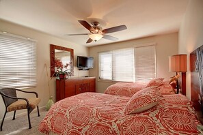 A bedroom with two beds, a ceiling fan, a TV, a dresser, a chair, and a lamp. - Royal Mauian, #601 2 Bedroom Condo by RedAwning (Kihei)